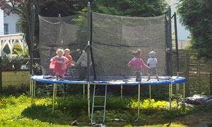 Kinder hüpfen auf einem Trampolin im Garten der Tagesmutter Jannette Haas in Rösrath.