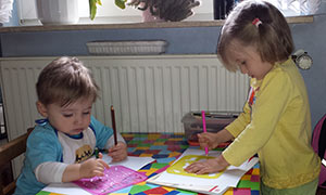 Zwei Tageskinder von Tagesmutter Jannette Haas malen mit Malschablonen.