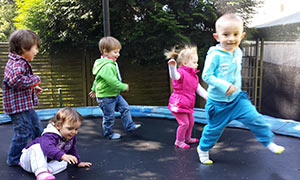 Auf Trampolin tobende Kinder im Garten von Tagesmutter Jannette in Rösrath.