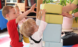 Zwei kleine Jungen bauen einen hohen Turm mit Schaumstoffbausteinen