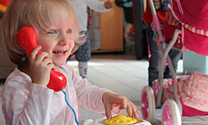 Mädchen mit Spielzeug-Festnetztelefon