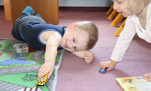 Junge und Mädchen spielen in der Spielecke von Tagesmutter Jannette Haas toben mit Autos.