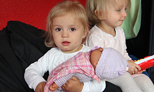 Mädchen mit Puppe auf dem Arm-